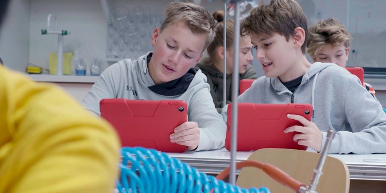 Zwei Schüler mit Tablets im Chemieunterricht