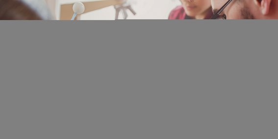 Schüler im Physik-Unterricht mit Atom-Modell